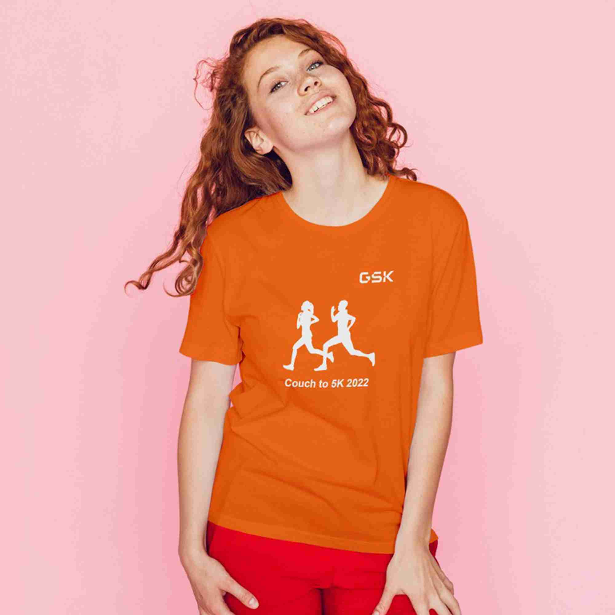 Woman wearing an orange t-shirt featuring a running graphic and text 'Couch to 5K 2022'.