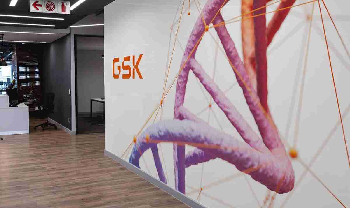 Wall art in GSK office featuring a woman in a hard hat and the text 'Uniting science, technology & talent'.