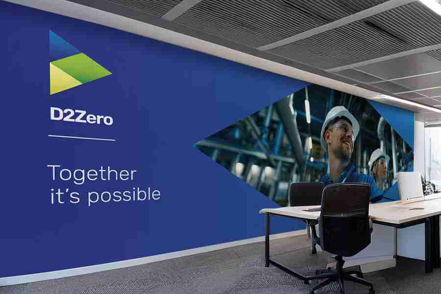 Wall display featuring D2Zero branding and two individuals in hard hats in an office setting.
